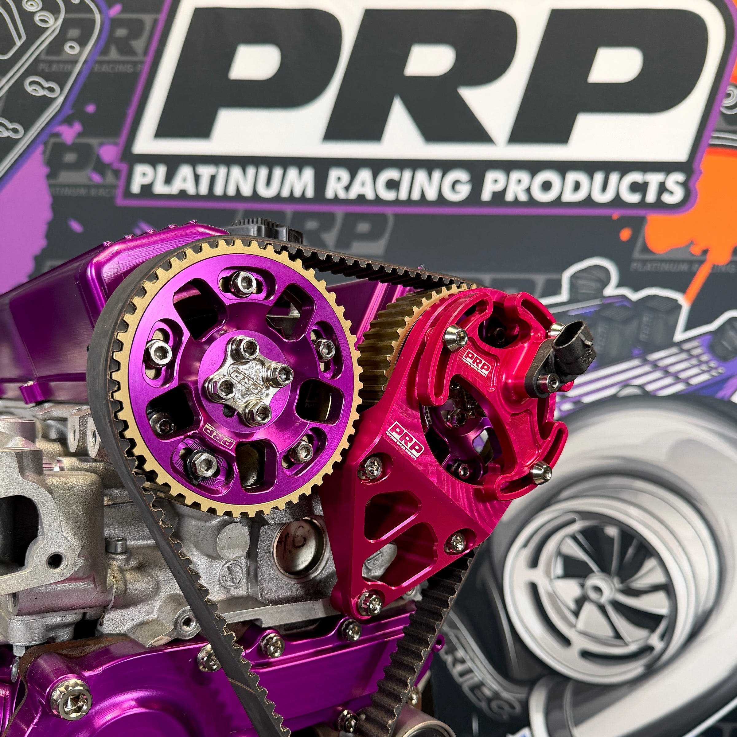 Close-up of purple and red engine components with PRP Platinum Racing Products branding in the background.