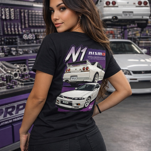 Woman wearing a black t-shirt with car graphics and 'N1' branding in a garage setting.