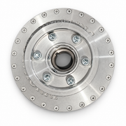 A polished metallic circular mechanical component, likely a clutch plate or flywheel, featuring a central hub with six bolt holes and a flange rim with evenly spaced rivets and engraved text.